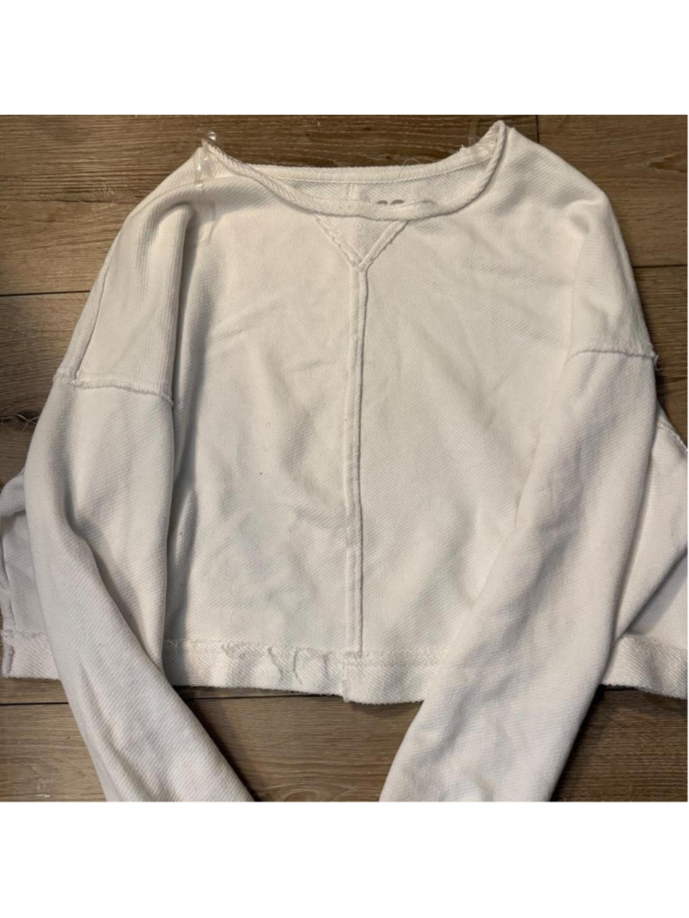 White deconstructed sweatshirt with exposed seam detailing, raw/frayed edges.